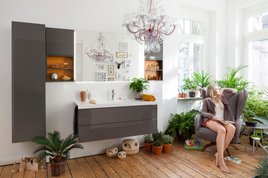 Ein Badezimmer mit vielen Pflanzen und einer Frau in einem Sessel