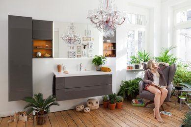 Ein Badezimmer mit vielen Pflanzen und einer Frau in einem Sessel