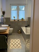 Badezimmer in zeitgemäßer Gestaltung mit bodenebener Dusche